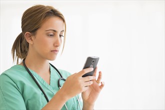 Young female doctor using smart phone.