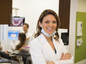 Portrait of dentist with colleague and patient in background
