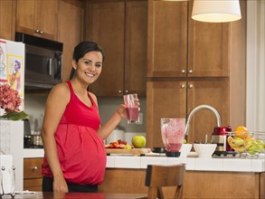 Portrait of pregnant woman with fruit cocktail