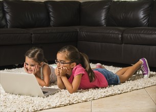 Girls (6-7, 8-9) using laptop at home
