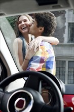 Couple kissing outside of car