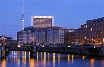 Illuminated riverfront skyline with television tower