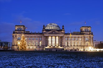 Illuminated Bundestag building and snowy lawn