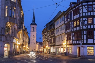 Illuminated city street and Allerheiligenkirche bell tower