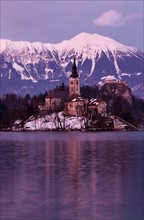 View of Church of the Assumption with lake and mountain