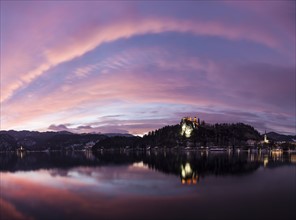 Clouds over Lake Bled and illuminated Church of the Assumption