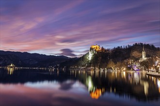 Lake Bled and illuminated Church of the Assumption reflecting in lake