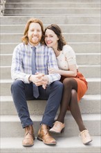 Smiling couple sitting on steps