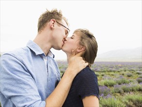 Young couple kissing with field on background