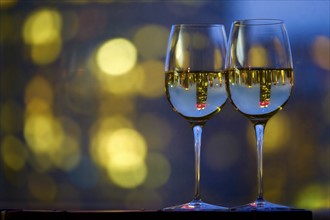 Two wineglasses with white wine. USA, New York, New York City.