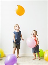 Children (2-3) playing with balloons