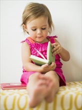Little girl (2-3) holding book