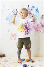Boy (2-3) showing hands after painting on wall