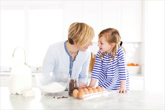 Girl (4-5) talking with mom in kitchen