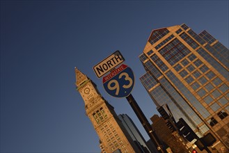 Road sign and office buildings at sunrise