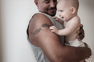 Studio shot of baby girl (2-5 months) with her father.