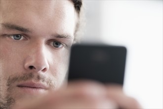 Close-up of mid-adult man texting.