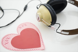 Studio shot of heart shaped paper cutout and headphones
