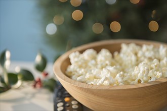 Bowl of popcorn with Christmas decorations in background