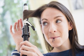 Woman using curler to do her hair