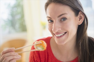 Portrait of woman eating sushi