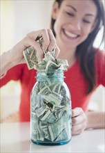 Woman putting money into jar