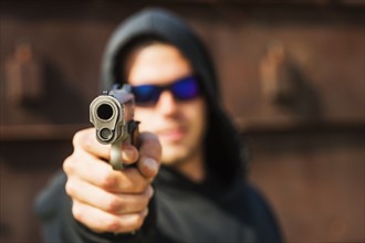 Man with handgun pointing towards camera