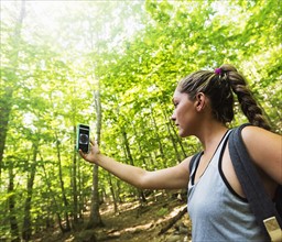 Female hiker looking at compass on phone