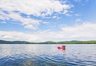 Young woman relaxing on lake in pool raft