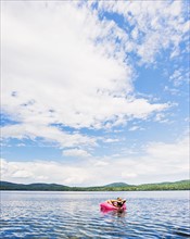 Young woman relaxing on lake in pool raft