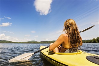 Young woman kayaking on lake
