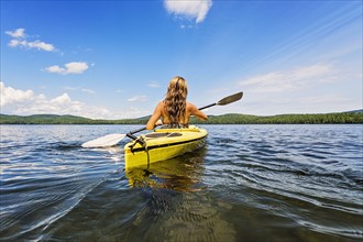 Young woman kayaking on lake