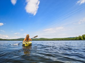 Young woman kayaking on lake