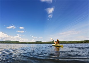 Young woman kayaking on lake