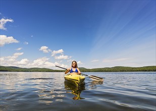 Young woman kayaking on lake