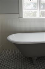 White bathtub by window