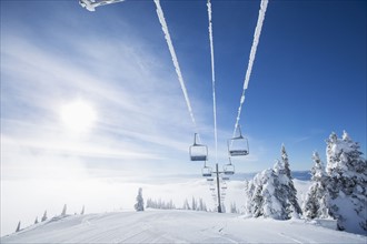Ski lift at sunlight against blue ski
