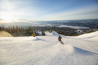 Two people on ski slope at sunlight