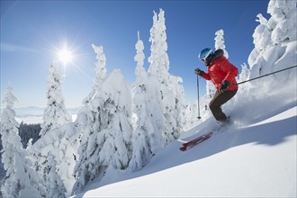 Mature woman on ski slope at sunlight