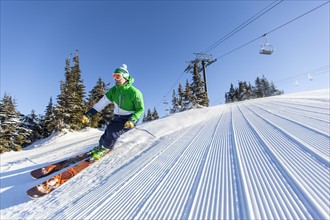 Mature man on ski slope under blue sky