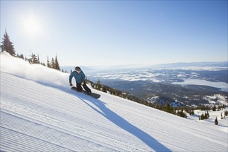 Mature man on ski slope at sunlight