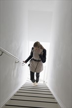 Woman walking up stairs and talking on phone