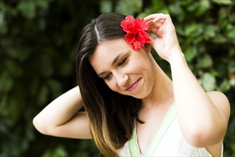 Woman putting tropical flower in her hair