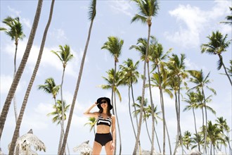Woman on beach against palm trees