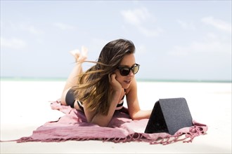Woman with tablet on tropical beach