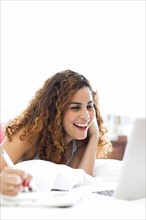 Woman with laptop in bed