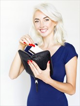 Studio shot of woman holding wallet and credit card