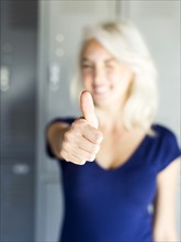 Woman holding thumb up