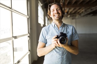 Smiling man with digital camera