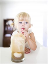 Girl (2-3) drinking milkshake